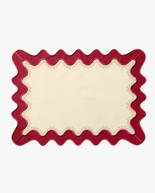 A cream placemat with a red boarder