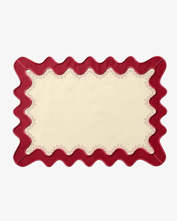 A cream placemat with a red boarder