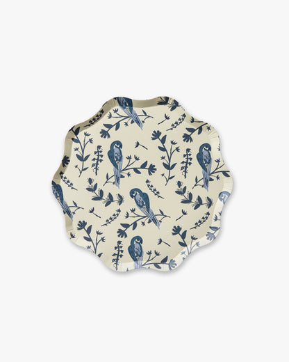Round decorative plate with blue bird and leaf pattern on a white background