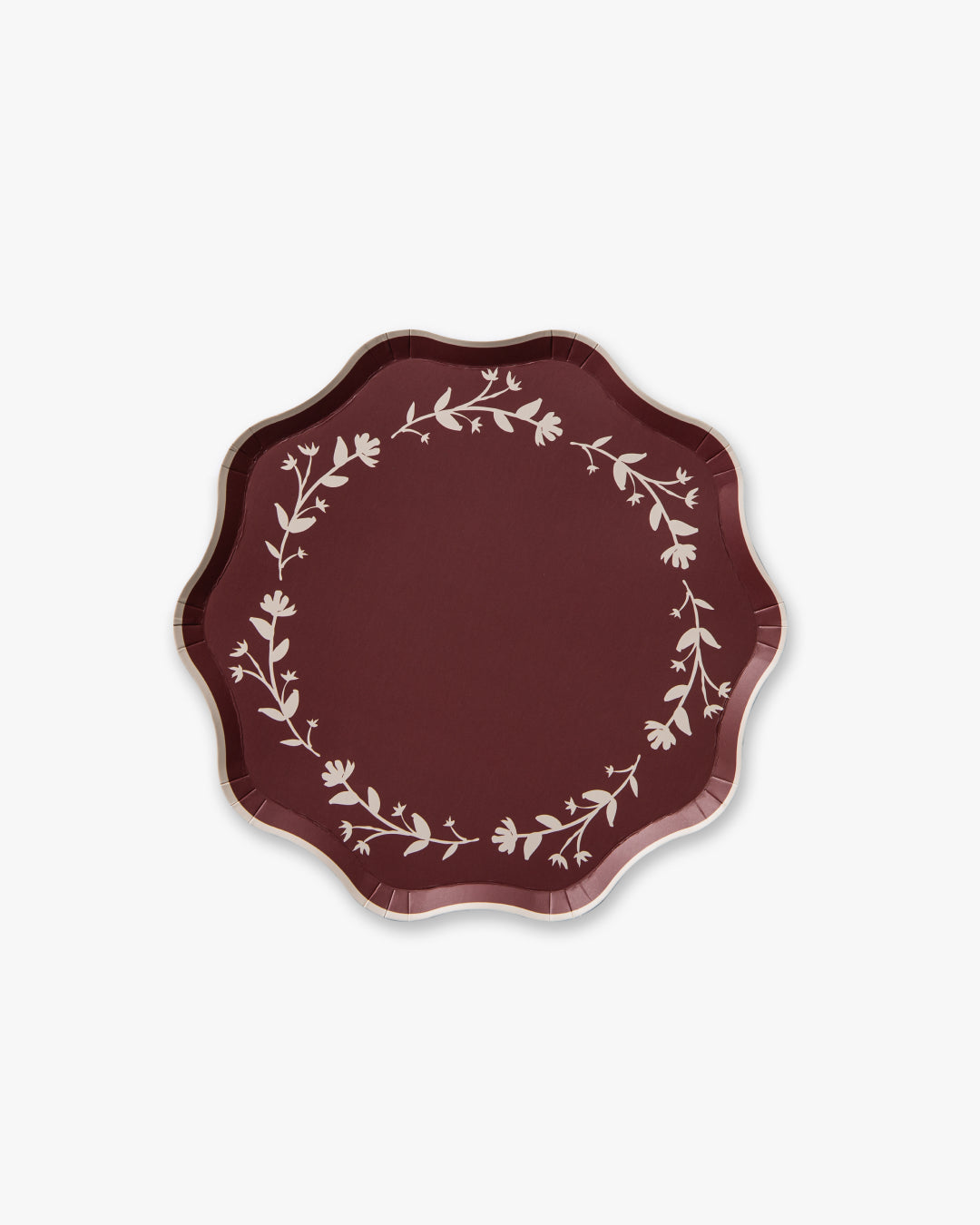 Decorative deep red plate with floral pattern on a white background