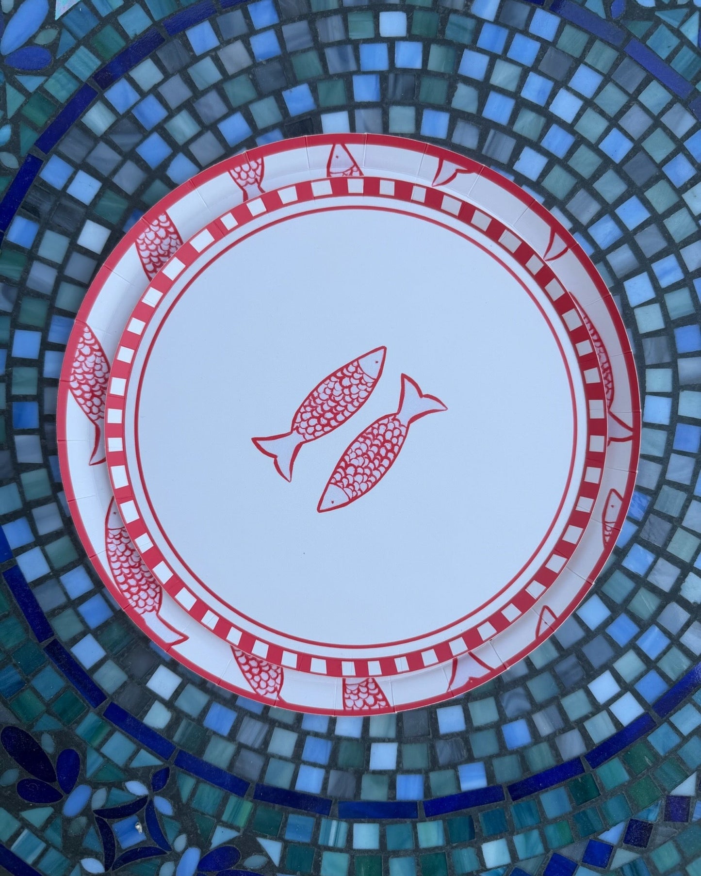 two plates layered with fish on them on a tile table