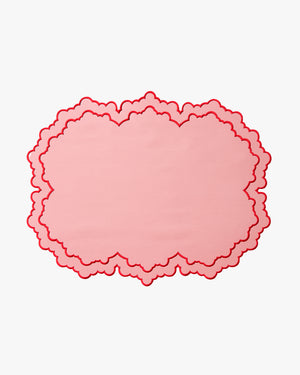 Pink scalloped placemat with a border on a white background