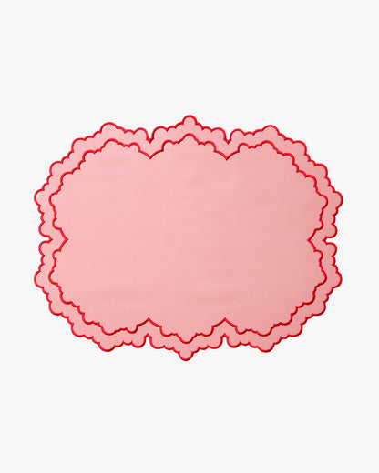 Pink scalloped placemat with a border on a white background