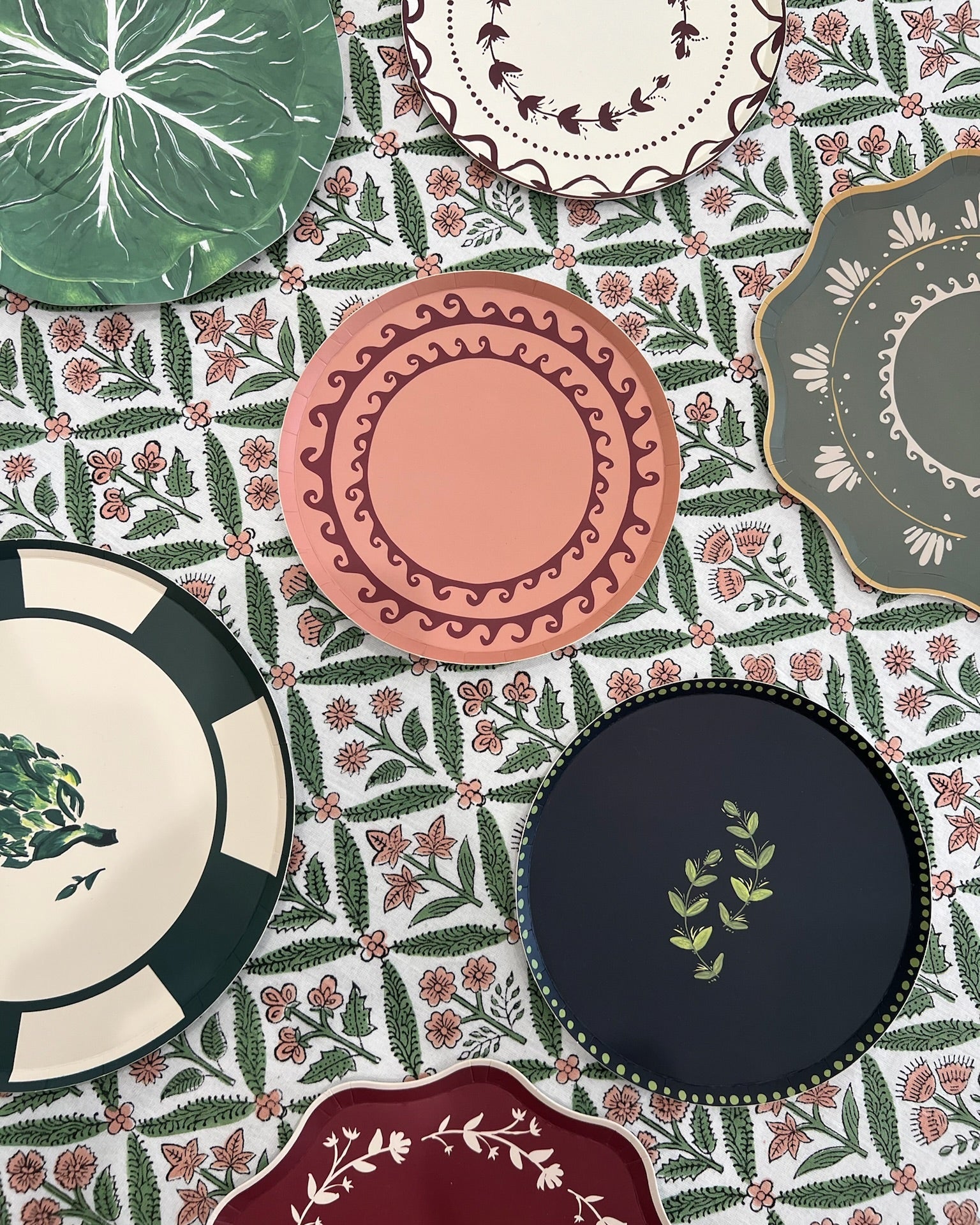 Collection of decorative plates with floral patterns on a matching fabric background
