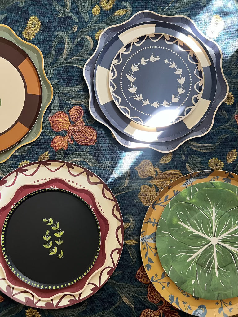 Four decorative plates with various patterns on a textured surface.