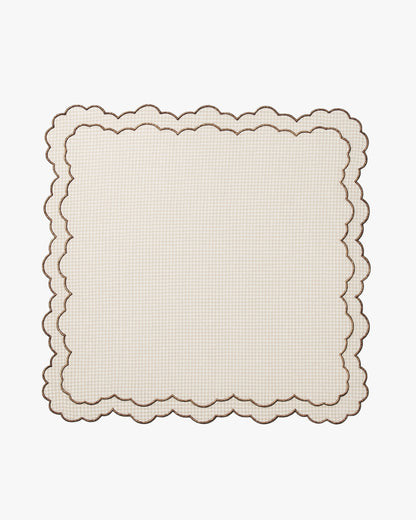 Beige checkered scalloped placemat on a white background