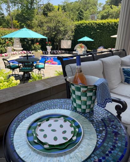 plates on a tile table with a pool in the background