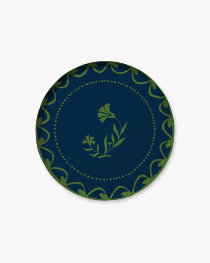Navy blue plate with green decorative border and floral design 