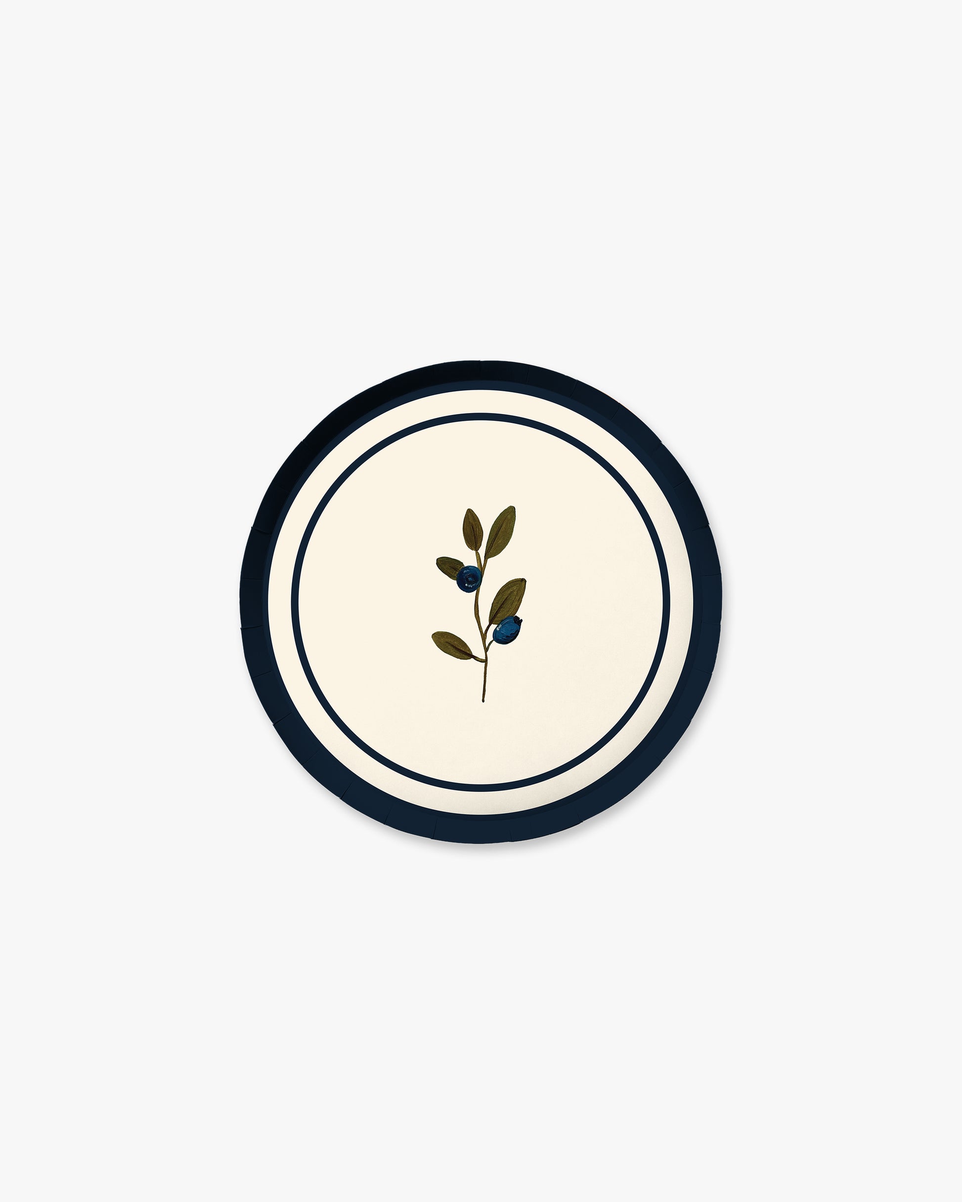 A round decorative plate featuring a cream center with a small botanical illustration of a leafy olive branch, framed by a dark navy blue border and a thin white ring.