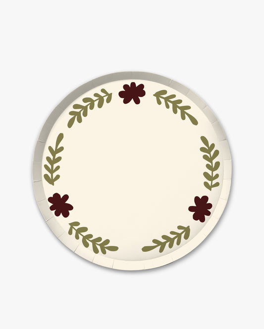 a cream decorative plate with brown and green floral designs