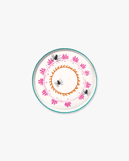 7-inch round decorative paper plate with a cream background, orange sun border, pink floral wreath, teal dotted circle, and three black spider illustrations.