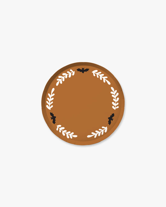Orange colored paper plate with white colored fern stem border and black bat detailing. 