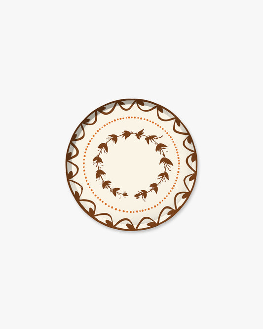 7-inch round decorative paper plate in a warm cider cream color with a brown floral border, inner floral wreath, and orange dotted circle.