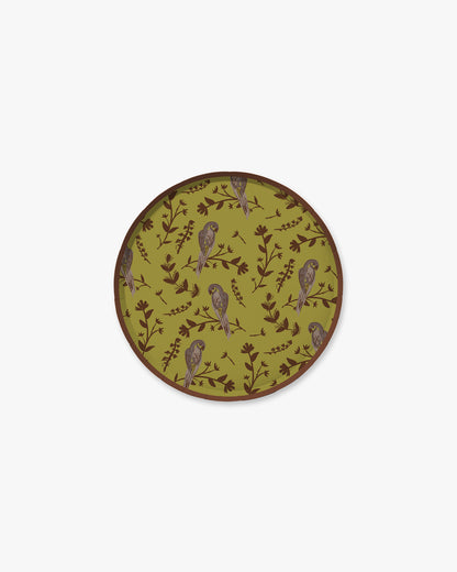 A green plate with a floral and bird pattern.