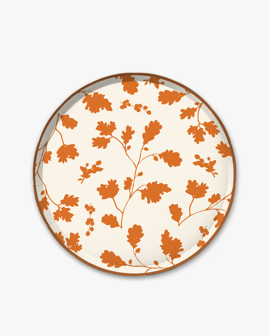 Cream paper plate with orange silhouette pattern of fall leaves. 
