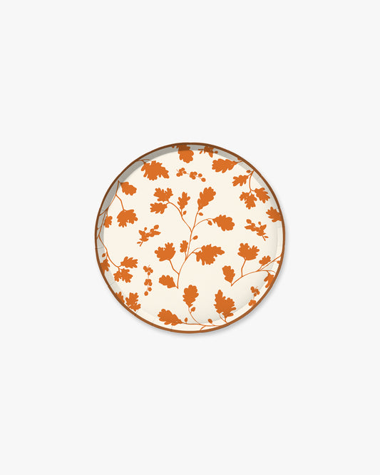 Cream paper plate with orange silhouette pattern of fall leaves. 