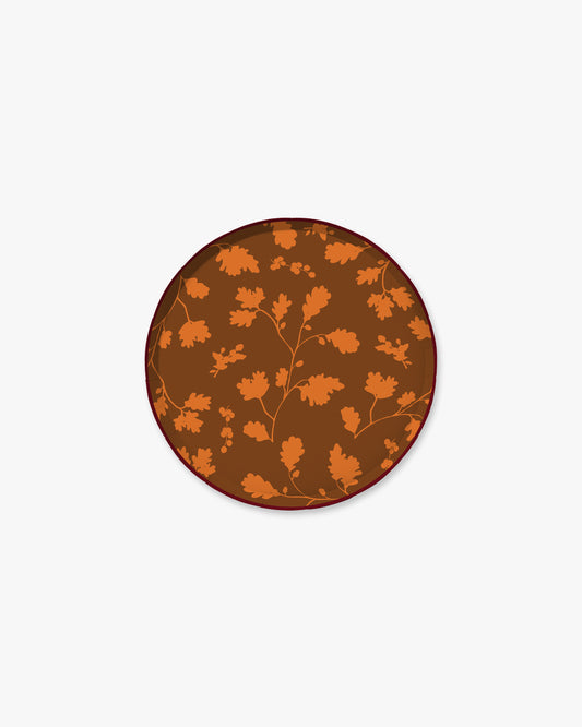 Brown paper plate with orange silhouette pattern of fall leaves. 