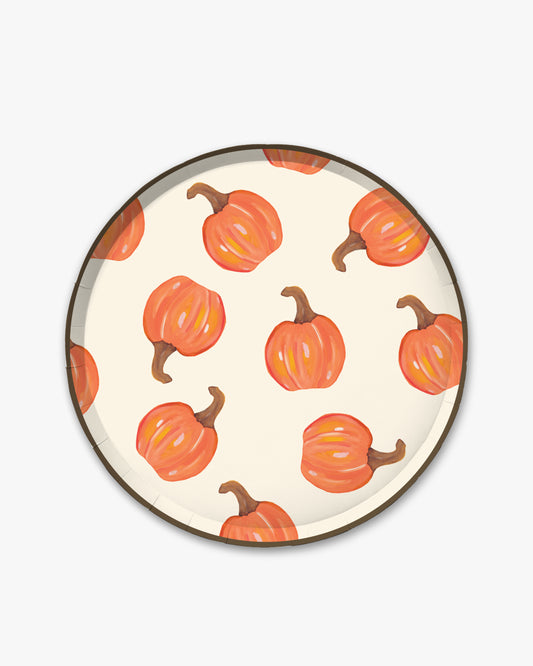 Cream colored paper plate with orange pumpkin pattern and a dark brown edge. 