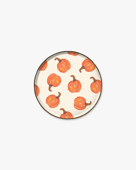 Cream colored paper plate with orange pumpkin pattern and a dark brown edge. 