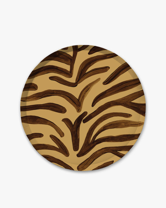 A round decorative plate featuring a bold zebra-like animal print pattern in dark brown and tan, shown against a plain light gray background.