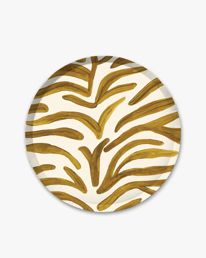 A round paper plate featuring a bold, organic gold pattern on an off-white background, shown against a plain light gray backdrop.