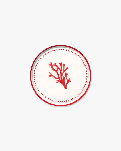A white plate with a red piece of coral in the center