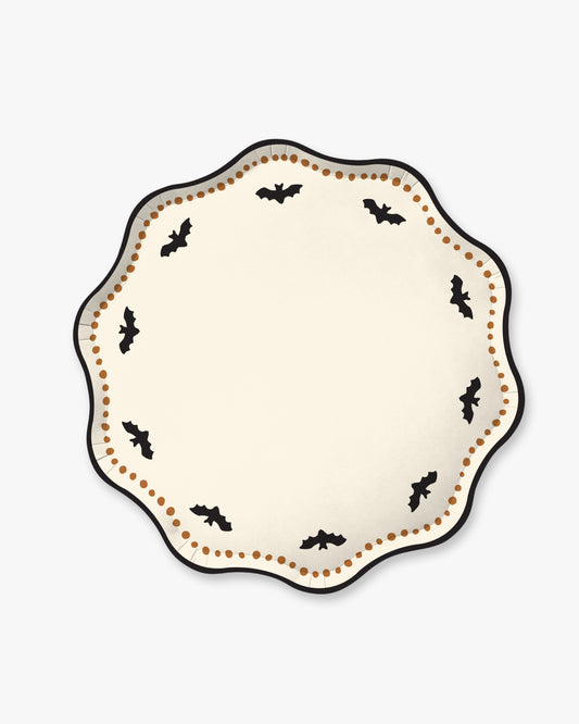 Cream colored paper plate with scalloped edges featuring a dotted orange border and black bat detailing.