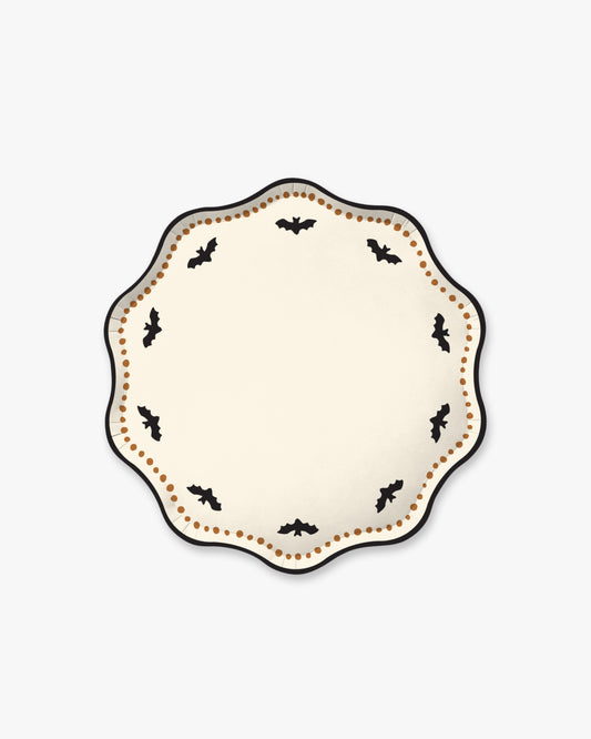 Cream colored paper plate with scalloped edges featuring a dotted orange border and black bat detailing.
