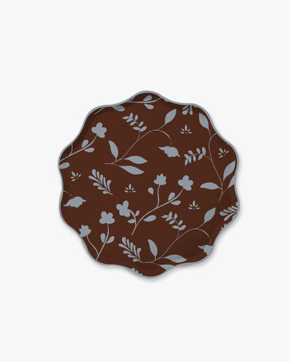 A scalloped oval plate featuring a dark brown background with a light gray floral and leaf pattern, shown against a plain light gray background.