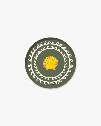 Round paper plate with a yellow shell design on a green background