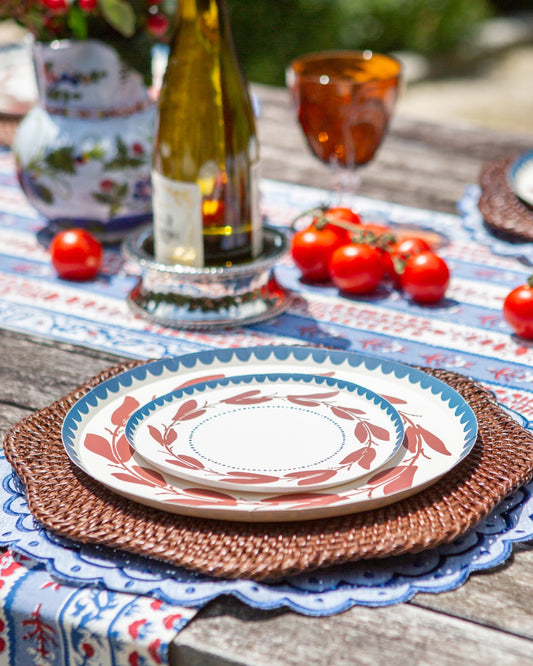 a red white and blue decorative plate with a leaf-like pattern
