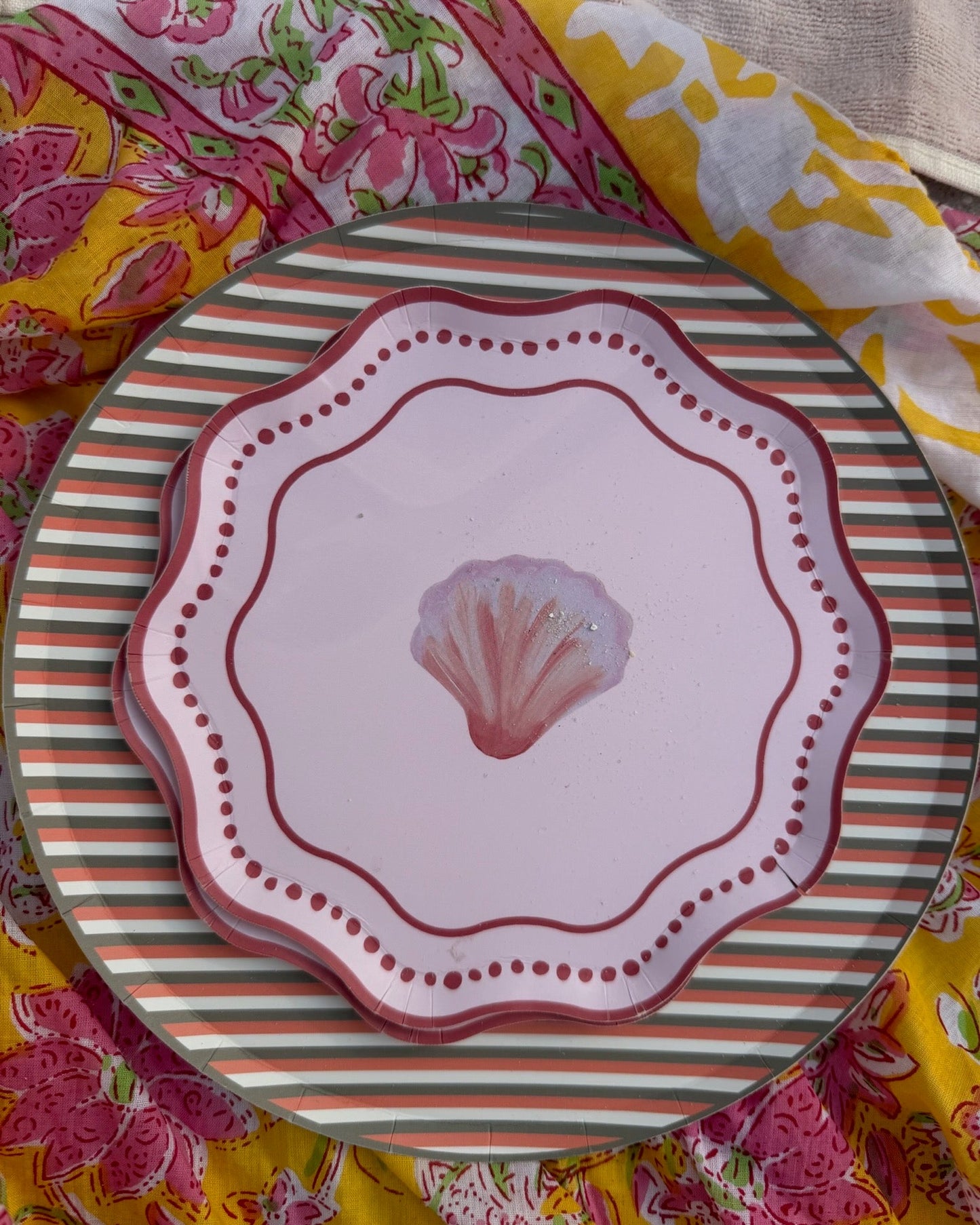 Decorative plate with shell design on a colorful fabric background