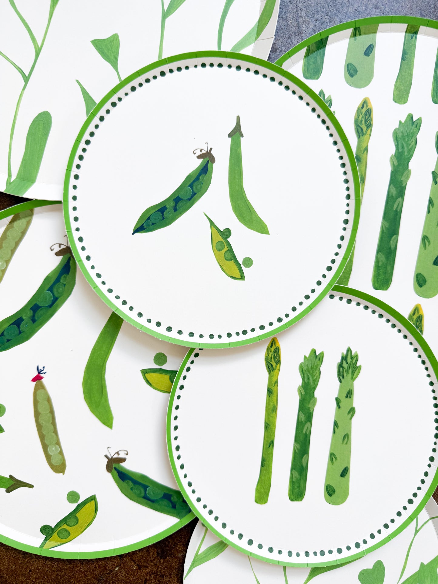 A stack of plates with sweet peas and asparagus on them