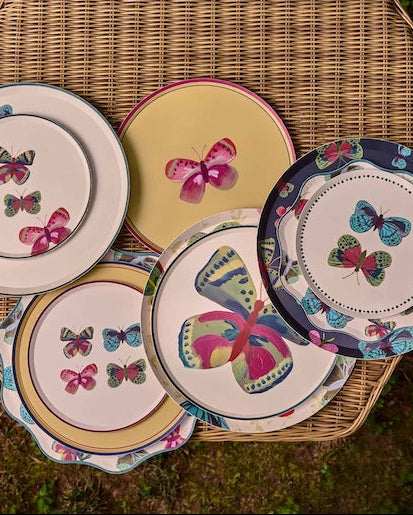 A table of decorative plates scattered with butterflies on them.