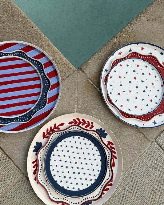 Three decorative plates with red, white, and blue patterns on a textured surface.