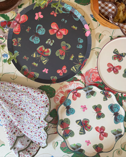decorative plates with a butterfly pattern on a floral tablecloth.