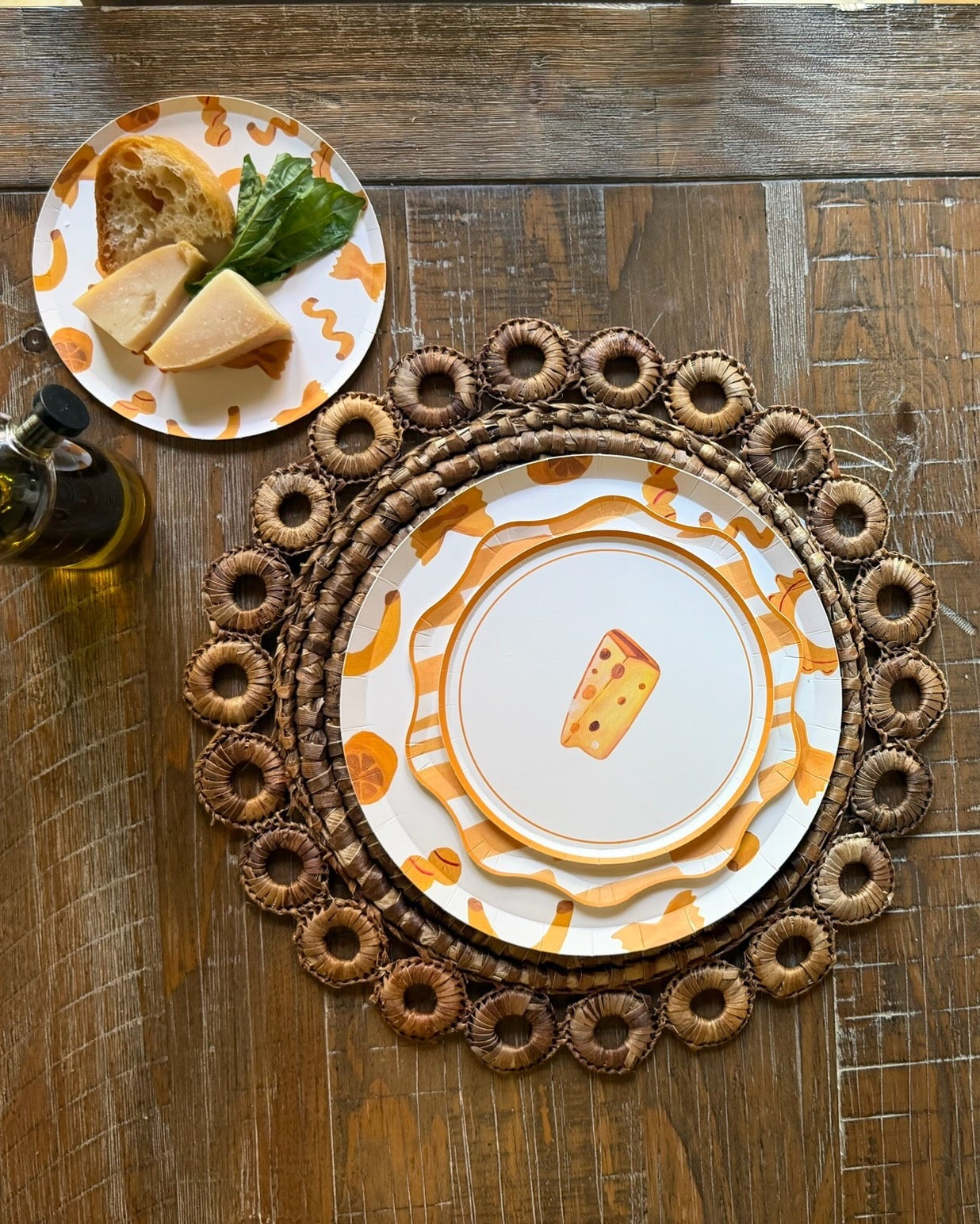 a dinner table with layered yellow plates with cheese on it.