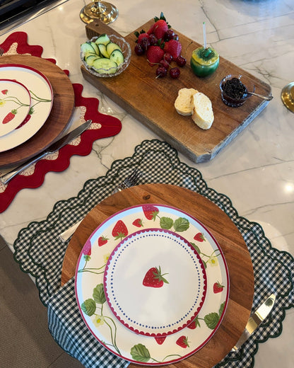 two place setting with plates that have strawberries on them. 